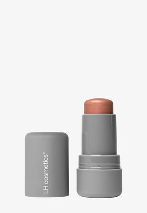 Grijze cilindervormige lippenstiftbuis zonder dop, die een afgeronde, lichtbruine crèmestift toont, met het label "LH cosmetics."