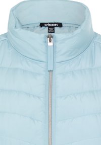 Light blue insulated vest with a high collar, vertical quilted pattern, and a silver front zipper. Brand tag visible inside the collar.
