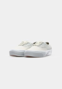 Witte canvas sneakers met textuuraccenten, ronde neus en tonale veters. Dikke rubberen zool met een lichtgrijze kleur en minimale details.