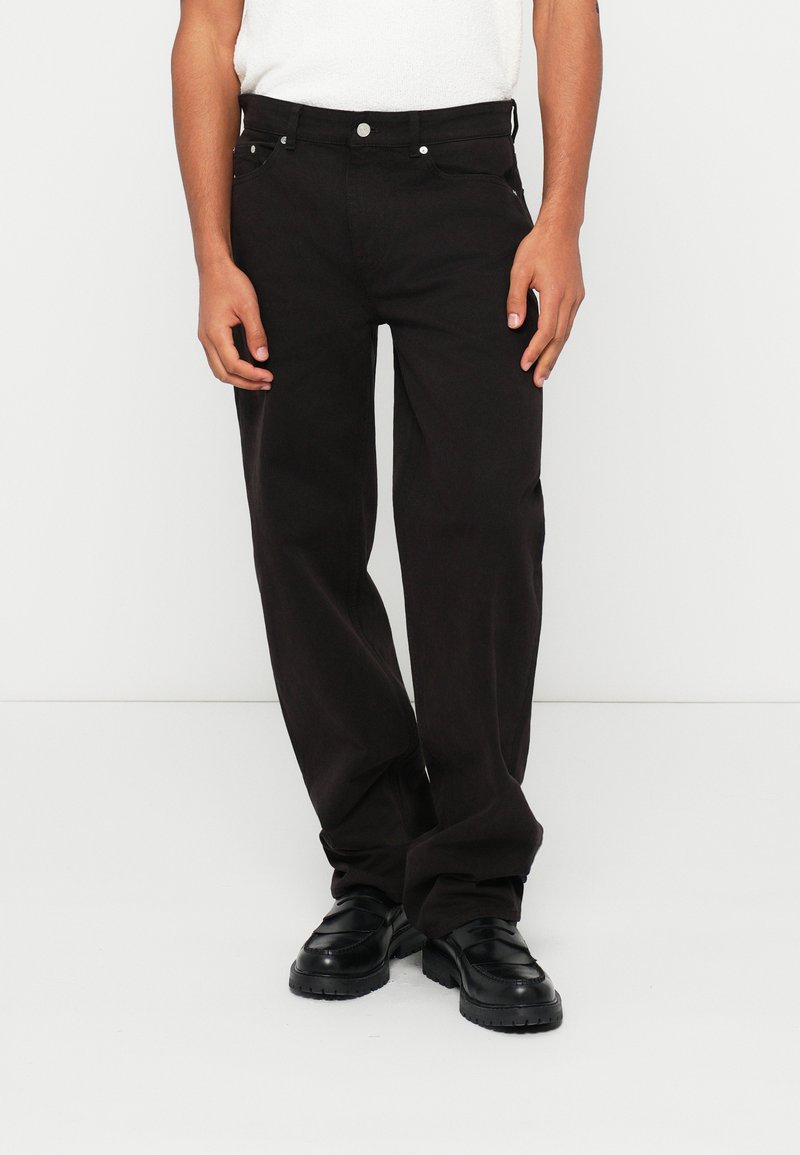 Pantaloni neri a gamba dritta realizzati in cotone resistente. Presentano una chiusura a bottone, cinque tasche e accessori in tonalità argento. Texture liscia.