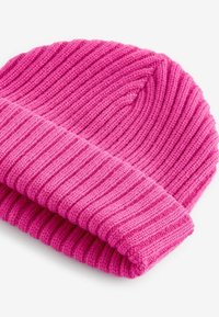 Berretto rosa lavorato a maglia con texture a costine e risvolto. Materiale morbido; design aderente e caldo, adatto per il freddo.