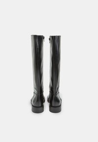 Schwarze, knielange Stiefel aus Leder mit glatter Textur, hinteren Reißverschlüssen und einer flachen, abgerundeten Spitze. Minimalistisches Design und schlichte Silhouette.