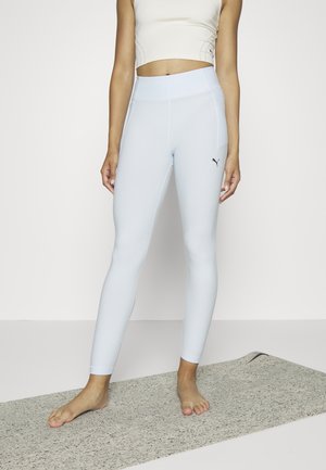 Ανοιχτό μπλε κολάν με ψηλή μέση, φτιαγμένο από απαλό υλικό. Διαθέτει ένα μαύρο λογότυπο στο γοφό και διακριτές ραφές.