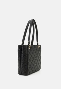 Sac cabas noir matelassé avec motif de logo embossé, doubles anses plates, accents de quincaillerie dorée et forme rectangulaire structurée.