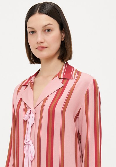 Langoe mouwen blouse met verticale strepen in tinten roze, rood en oranje. Zachte stof met een kraag en strikdetail bij de halslijn.