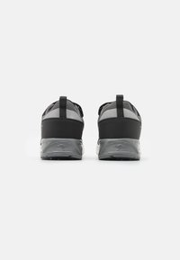 Schwarze und graue Sportschuhe mit einer strukturierten Sohle, verstärktem Fersenbereich und Rückziehlaschen, die ein elegantes Mesh-Design und keine sichtbaren Schnürsenkel aufweisen.