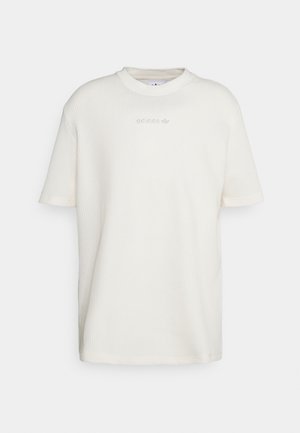 Camiseta de Adidas de manga corta blanca con una sutil textura tipo waffle y un pequeño logotipo bordado centrado cerca del escote.