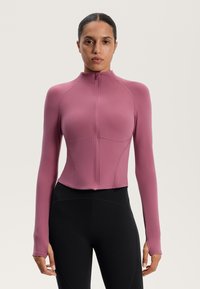 TÆTSITTENDE, langærmet jakke i mauve med hel frontlynlås, flade sømme og tommelhuller ved manchetterne, lavet af strækbart, glat stof.