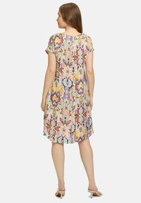 Kurzes, kurzärmeliges Kleid aus leichtem, gemustertem Stoff mit pastellfarbenen Blumenmotiven in Tönen von Rosa, Blau und Braun, das eine entspannte Passform bietet.