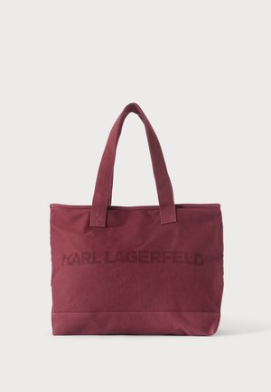Vinrød Karl Lagerfeld tote taske med to håndtag og logo foran mod en ens hvid baggrund.