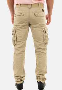 Beige cargo broeken met een comfortabele pasvorm, voorzien van meerdere grote zakken, een duurzame stofstructuur, een elastische tailleband en taps toelopende boorden.