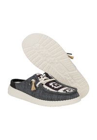 Zapatos slip-on de mezclilla gris oscuro con suela blanca, acentos en tela estampada en crema y burdeos, y detalle decorativo de borlas.