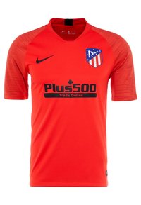 Camiseta de fútbol roja del Atlético de Madrid con el logo de Nike en negro y el patrocinador Plus500 Trade Online en el frente, de mangas cortas con patrones sutiles.