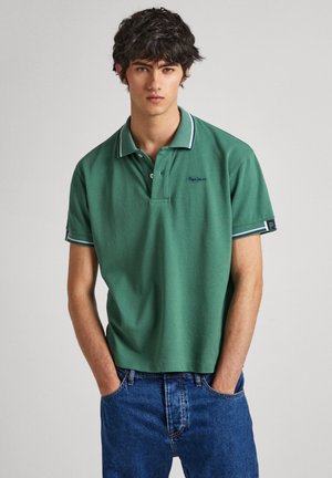 Polo verde hecho de suave algodón, con un collar clásico, tapeta de tres botones y acentos a rayas en contraste en las mangas.
