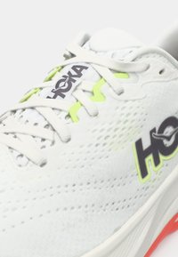 Λευκό και νέον πράσινο παπούτσι για τρέξιμο Hoka με κορδόνια, επάνω μέρος από αεριζόμενο πλέγμα και μερικό λογότυπο στο πλάι και στη γλώσσα.