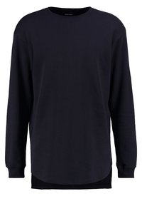 Sudadera unisex de manga larga en color marino con cuello redondo, corte relajado y dobladillo curvado. Fabricada en suave material de algodón con puños de canalé.