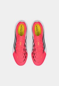 Φωτεινά ροζ αθλητικά παπούτσια με μαύρες λεπτομέρειες, υφή στην επάνω επιφάνεια και ελαφρύ σχεδιασμό. Διαθέτουν λωρίδα για εύκολη εφαρμογή και μαλακή σόλα.