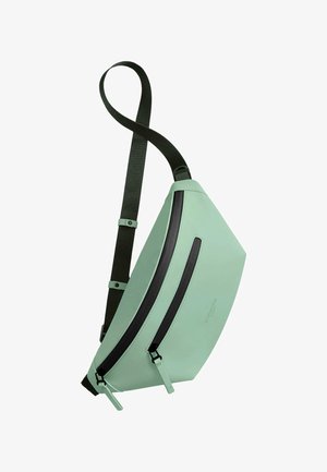 Mintgrønn sling bag laget av glatt materiale, med en diagonal glidelåslomme med svarte detaljer og en justerbar stropp.