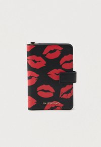 Portafoglio in pelle nera con un motivo di labbra rosse, dotato di chiusura a linguetta e marchio dorato "VALENTINO" sul fondo.