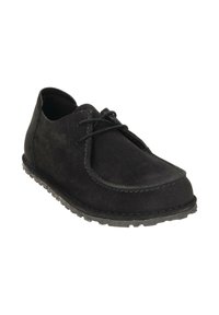 Zwarte suède casual veterschoen met een geprofileerde rubberen zool en zichtbare stiksels langs de randen, onder een schuine hoek om de voor- en zijkantdetails te tonen.