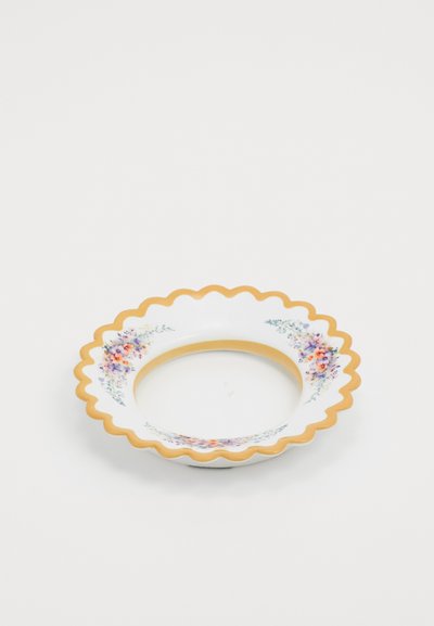 Assiette en céramique avec un bord en dentelle, blanche avec des motifs floraux en violet et orange, et une bordure dorée autour du bord. Forme circulaire.