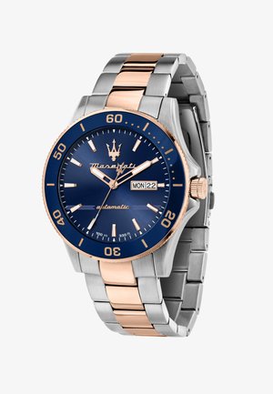 Silver och roséguld rostfritt stål armbandsur med blå urtavla, vita timmarkörer, datumvisning och en roterande bezel.