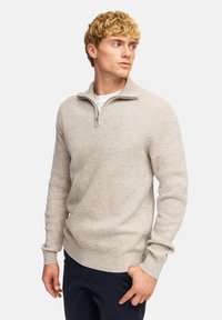 Strickpullover in Hellbeige mit Reißverschlusskragen, gerippten Bündchen und Saum, aus strukturiertem Material, mit taillierter Passform.