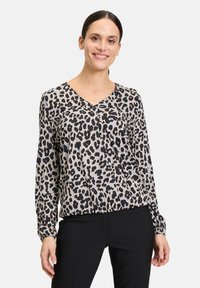 Bluse mit Leopardenmuster aus leichtem Stoff, mit V-Ausschnitt, langen Ärmeln und einem Farbzusammenspiel aus Schwarz und Beige. Maßgeschneiderte Passform an der Taille.
