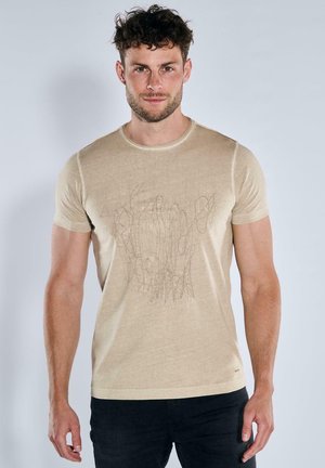 Beige T-Shirt mit kurzen Ärmeln aus weichem Stoff, mit einem strukturierten abstrakten Design auf der Vorderseite und einem Rundhalsausschnitt.