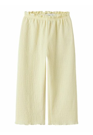 Pantalon large texturé de couleur crème avec une taille élastique et un ourlet légèrement froncé sur fond blanc.