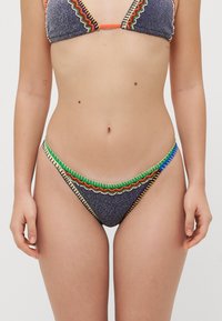 Bikini-Set aus einem blauen Strukturstoff mit bunten Perlendezenten und Zickzacknähten entlang der Kanten des Oberteils und des Unterteils.