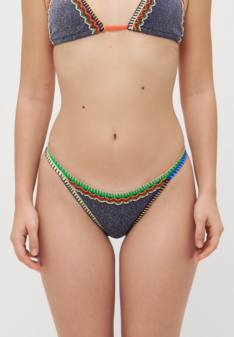 Bikini-Set aus einem blauen Strukturstoff mit bunten Perlendezenten und Zickzacknähten entlang der Kanten des Oberteils und des Unterteils.