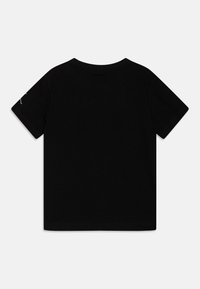 Black cotton t-shirt with short sleeves, round neckline, and a smooth texture. Features a small design on the left sleeve.