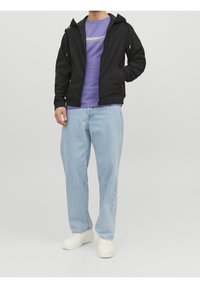 Czarna kurtka na zamek z kapturem, zestawiona z fioletowym t-shirtem i jasnoniebieskimi dżinsami. Buty to białe trampki. Prosty design i luźny krój.