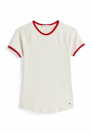 Camiseta de manga corta de canalé en color crema con cuello redondo y puños de contraste en color rojo. Presenta un dobladillo curvado y un pequeño logo cerca de la parte inferior izquierda.