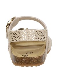 Hellbeige Sandale mit perforiertem Riemendesign und goldenen Akzenten. Korkähnliches Fußbett und strukturierte Gummisohle für besseren Halt.