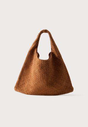 Sac cabas en daim marron avec un motif en losange tissé et une anse douce et arrondie sur fond blanc.