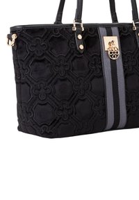 Sac fourre-tout en velours noir avec un motif floral matelassé, une bande grise, des accents de quincaillerie dorée et deux bretelles noires.