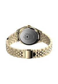 Goldfarbene Metallarmbanduhr mit Gravur auf der Rückseite, die eine Augenillustration sowie die Markennamen Timex und Jacqueline Aiche zeigt.