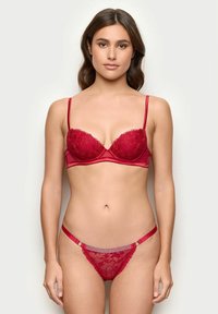 Rød blonde BH og matchende g-streng med satin detaljer, justerbare stropper og dekorative elementer. Glat, indviklet blondermønster over det hele.