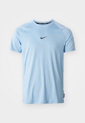 Camiseta deportiva azul claro hecha de una tela suave. Presenta un cuello redondo, mangas cortas y un pequeño logo negro de Nike en el pecho.