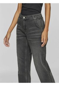 Jeans de mezclilla gris oscuro con cintura alta, corte recto, cinco bolsillos y costuras en contraste. Presenta un cierre de botón único.