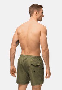 Pantaloncini da bagno verde oliva con cintura elastica, dettaglio della tasca posteriore e tessuto liscio; modello mostrato di spalle.
