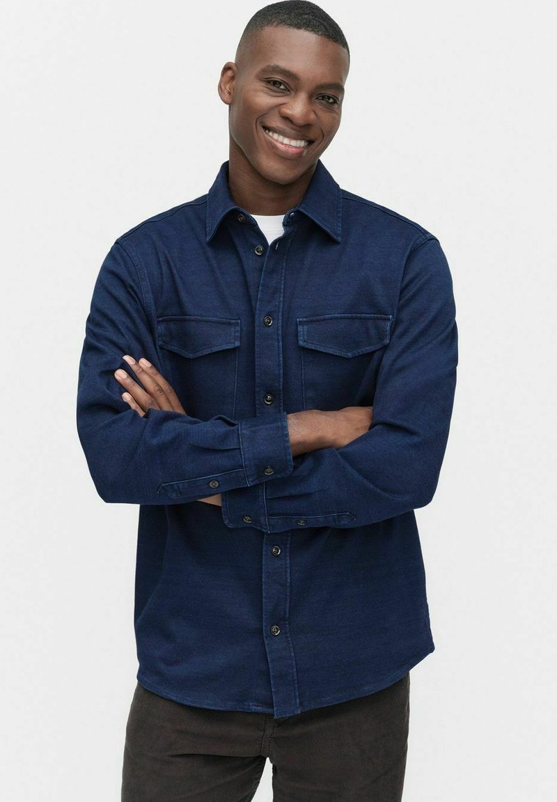 Marineblauwe overhemd met knopen, gemaakt van een gestructureerde stof, met twee voorzakken, een kraag en een recht afgewerkte zoom.