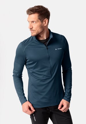 Pullover da uomo a maniche lunghe di colore blu scuro, realizzato in tessuto texturizzato, presenta una zip a quarti e un logo sul lato sinistro del petto, evidenziando un design funzionale.
