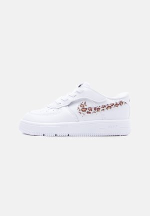 Fehér Nike Air Force 1 sportcipő alacsony profilban, oldalán leopárdmintás Nike logo és fehér cipőfűzők.