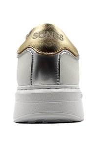 Sneaker bianca con accenti argento e oro, caratterizzata da una finitura liscia, forma arrotondata e suola testurizzata. Logo "SUN68" visibile sul tallone.