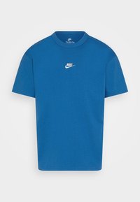 Blå bomullströja med rund hals, korta ärmar och en vit Nike-logga på bröstet. Slät textur, regular fit-design.