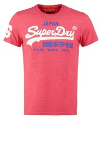 Maglietta rossa a maniche corte in cotone morbido, con logo bianco "SuperDry" con accenti blu e grafiche, scollo rotondo a girocollo.