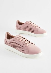 Lyserøde sneakers med en glat lædertå og teksturerede vævede sidepaneler, udstyret med flade snørebånd og en hvid gummisål.